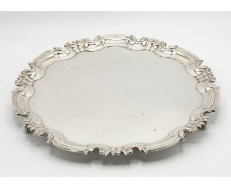 A George V silver salver, William Hutton & Sons Ltd., Sheffield 1915, circular with foliate Chippendale rim, on three foliate