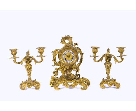 A French gilt bronze clock garniture, circa 1900, Rococo style, drum form clock and movement housing encased by scroll and fl