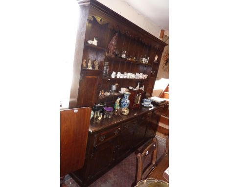 Georgian style cross-banded oak Farmhouse dresser with shaped frieze, the rack with two spice cupboards above the base with f