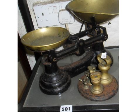 Set of old brass bell weights on cast iron stand and set of brass and iron kitchen scales