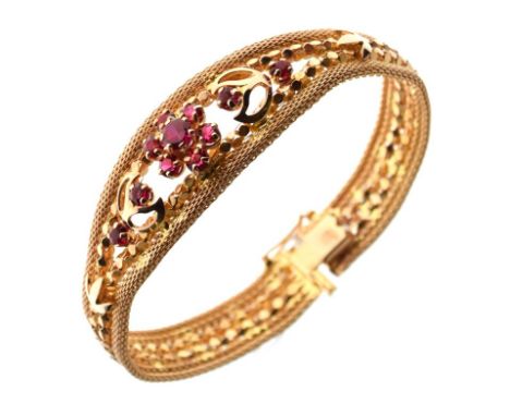Yellow metal and ruby flexible bracelet set central flowerhead cluster within mesh borders, stamped 750, 24.8g gross approx  
