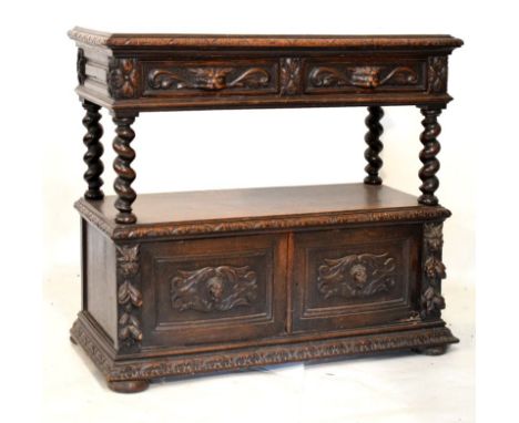 Late 19th Century carved oak carved buffet, the upper fitted two carved mask head drawers with open shelf below, the base fit