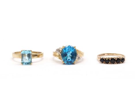 Three gold rings, comprising a 9ct gold single stone blue topaz ring, London, a 9ct gold blue topaz and diamond ring, import 