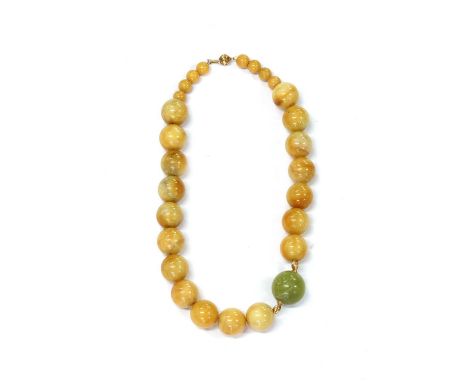A serpentine and jade bead necklace, with a central serpentine bead with gold fluted beads either side, to polished yellow ag