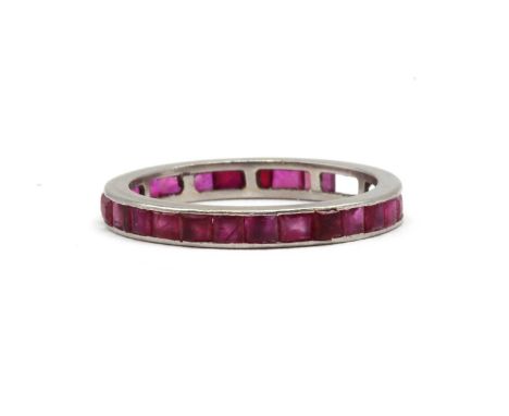 A ruby full eternity ring,with square step cut rubies, numerous stones deficient, all channel set to plain guards, tested as 