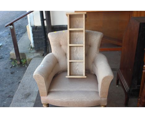 An upholstered button back arm chair together with a light oak CD rack