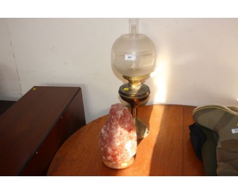 An oil lamp with glass shade and chimney; together with a salt rock lamp
