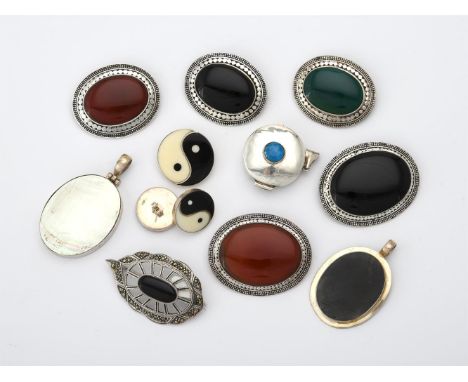 
	
		A collection of stained hardstone brooches, the oval hardstone panels within decorative silver coloured surrounds, toget
