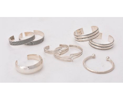 
	
		A collection of silver and silver coloured bangles, of various designs, stamped with London marks or 925, approximately 