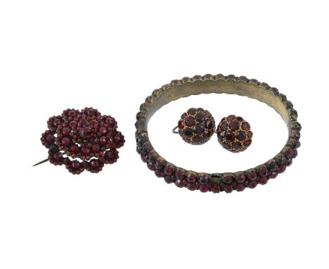 
	
		A pair of mid 20th century garnet earrings, the domed earrings with graduated round cut garnets, with screw back setting
