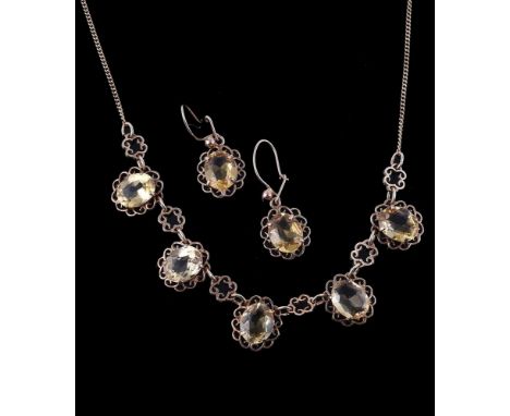 
	
		A 1970s 9 carat gold citrine necklace and earring suite, the necklace with five oval cut citrines within pierced scrolle