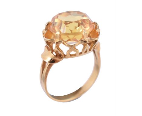 
	
		A synthetic yellow sapphire dress ring, the circular cut yellow sapphire within a pierced lobed surround, stamped K18, f