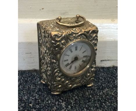 An embossed silver carriage clock on four bun feet. Birmingham. Approx. 311 grams. Est. £80 - £120.