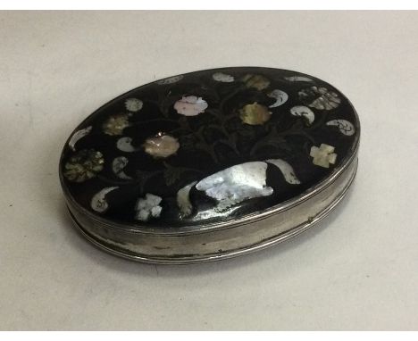 A silver and tortoiseshell inlaid oval snuff box depicting flowers. Circa 1730. Approx. 51 grams. Est. £250 - £300.