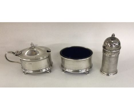 An engine turned silver three piece cruet with BGLs. Birmingham. By SP. Approx. 76 grams. Est. £65 - £75.