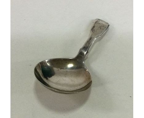 A large fiddle pattern silver caddy spoon with initialled terminal. London 1804. Approx. 11 grams. Est. £30 - £50.