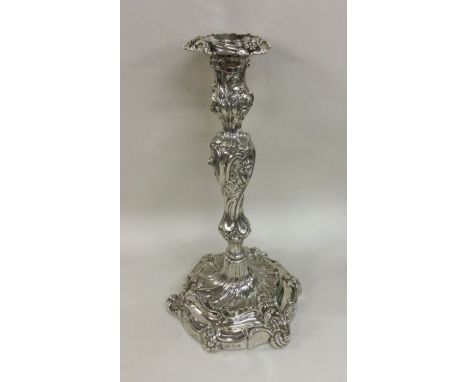 A massive George III silver candlestick with scroll decoration. Approx. 31 cms high. Approx. 1309 grams. Est. £250 - £350.