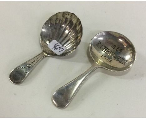 A Georgian silver caddy spoon with bright cut decoration. London 1802. Together with a plated example. Est. £50 - £80.