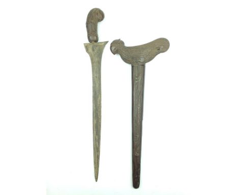 A Kris, 39cm watered steel blade, characteristic carved wooden hilt in the form of a bird, contained in its carved wooden sca