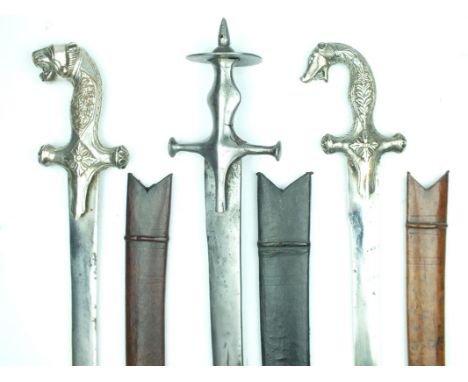 Three Indian Tulwar, the first with characteristic hilt with large disc pommel, the remainder with plated hilts, the first wi