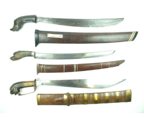 Three Malayan Golok, the first with 53cm heavy fullered blade, characteristic carved horn hilt, contained in its horn and bon