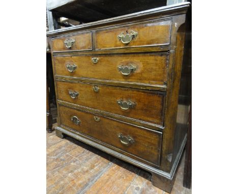 A Georgian oak bedroom chest of three long and two short graduated drawers with crossbanded detail, flanked by canted corners