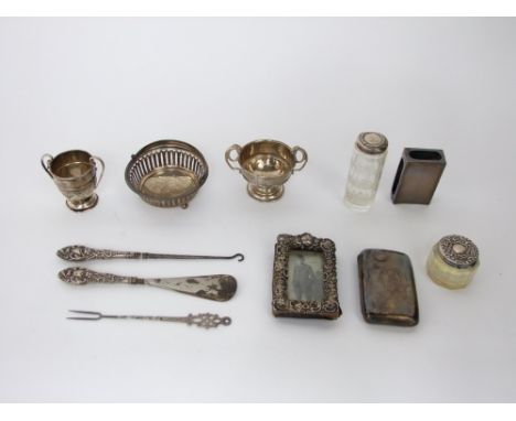 A collection of Victorian and later sterling silver items to include two small trophy cups, a pierced and footed basket, a si