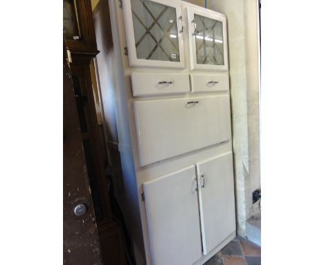 A 1950s kitchenette fitted with twin glazed doors over two cupboard doors, the fall front enclosing an enamel fitted surface 