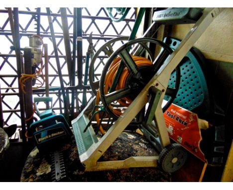 A miscellaneous collection of hand tools including a Backsaver fork, hose spools a hose cart, a Black and Decker shredder etc