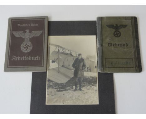 A collection of Austrian WWII ephemera including a black and white photograph of a pilot with his plane, two identity booklet