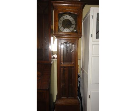 A 1920 period oak longcase clock, the front elevation enclosed by three bevelled edged glass plates, the engraved brass dial 