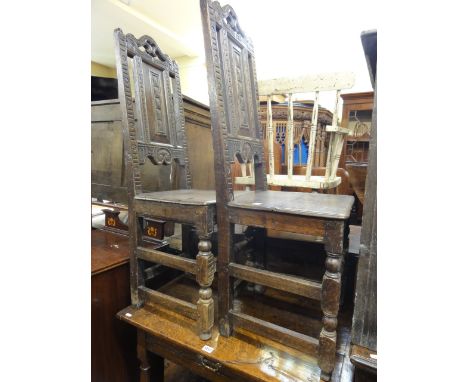 A pair of antique oak side/hall chairs with rectangular moulded panelled backs within carved frames over planked solid seats 