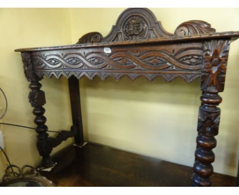 A Victorian oak hall table of rectangular form with geometric carved detail raised on bobbin supports