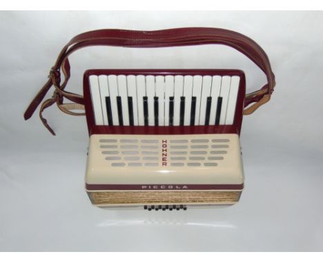 Hohner Piccolo piano accordion within a case with instruction manual