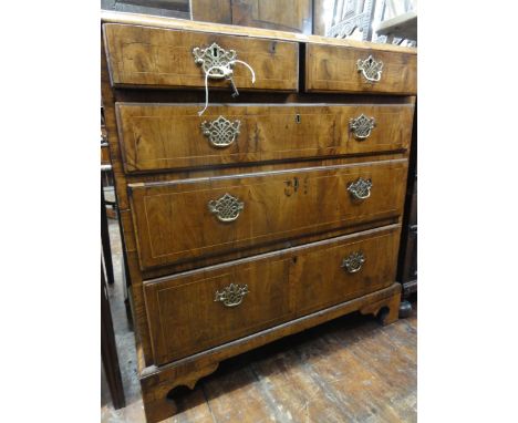 An 18th century walnut veneered bedroom chest of three long and two short graduated drawers with string banded inlay, oak lin
