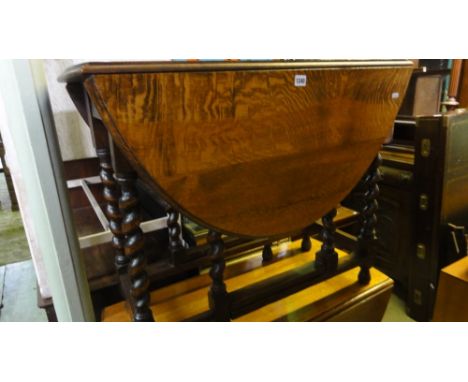 A 1920s oak gate leg occasional table on barley twist supports, together with an Ercol dark elm freestanding corner cupboard