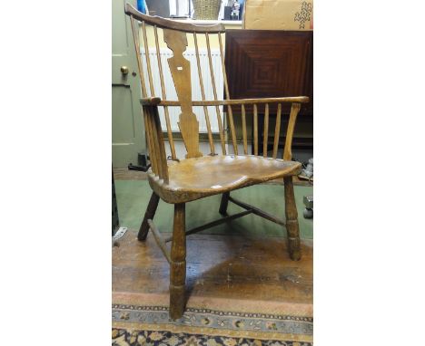 A late 18th century Windsor stick back elbow chair with vase shaped splat, saddle seat and turned supports, principally in el