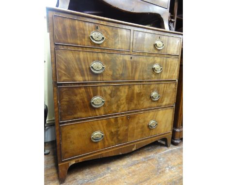 An early 19th century mahogany bedroom chest of three long and two short drawers with well matched figured veneers over a sha