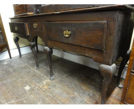 An 18th century dresser, principally in elm, raised on six pad feed enclosing an arrangement of three drawers around a centra