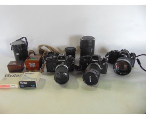A box containing a collection of vintage cameras and lenses, many by Nikon