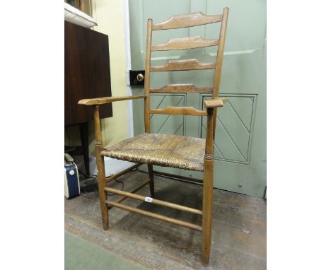 A Cotswold school ash wood ladder back armchair of traditional form with rush seat