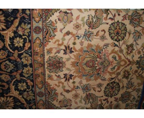 A large Persian style wool carpet with soft pink field and abstract floral, animal and other detail decoration set within wid