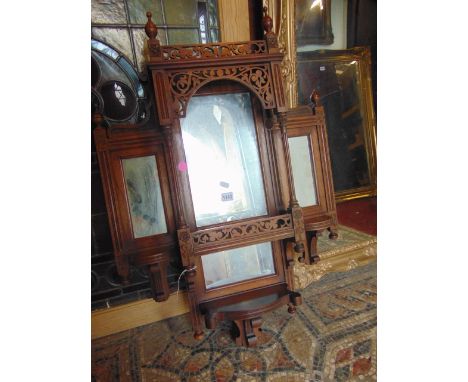 An Edwardian mahogany mirror backed wall shelf, the four mirror plates set within carved and moulded frame work, 90cm high