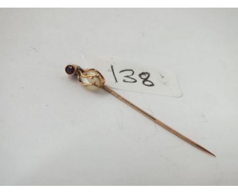 An antique arts &amp; crafts stick pin set with a garnet &amp; caged natural pearl