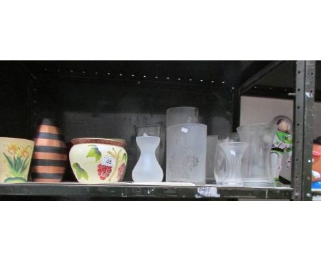 A shelf of ceramic and glass vases