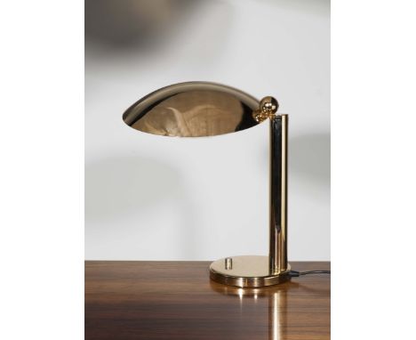 A GILT BRASS DESK LAMP, the rotating circular shade on a single column support and circular base, 51cm high