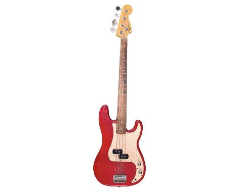 A Fender Squier 4-string bass guitar in red with white pickguard. In need of restoration