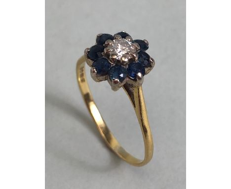 18ct yellow gold ring of daisy design, the  central diamond surrounded with 8 sapphires approximately size S and 3.1g