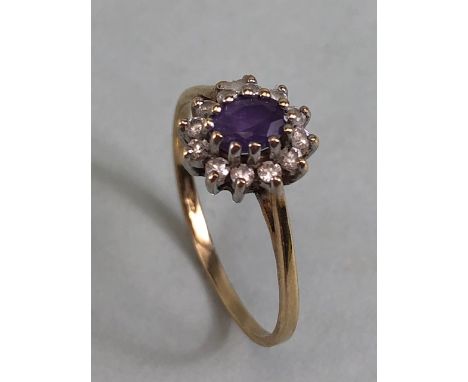 9ct gold ring set with a central amethyst surrounded by diamonds approximately size N and 1.2g 