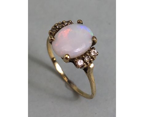 Oval cut opal set in an unmarked yellow metal setting with 6 diamonds approximate size J 1.3g